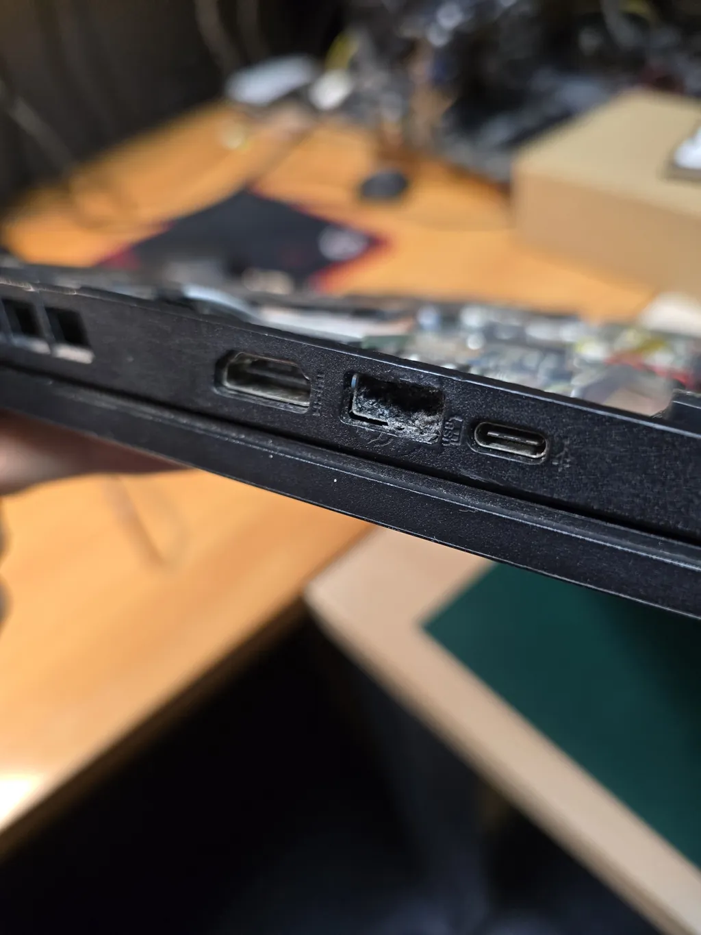 Uszkodzone gniazdo USB zalepione resztkami gąbki w Acer Nitro 5 przed wymianą