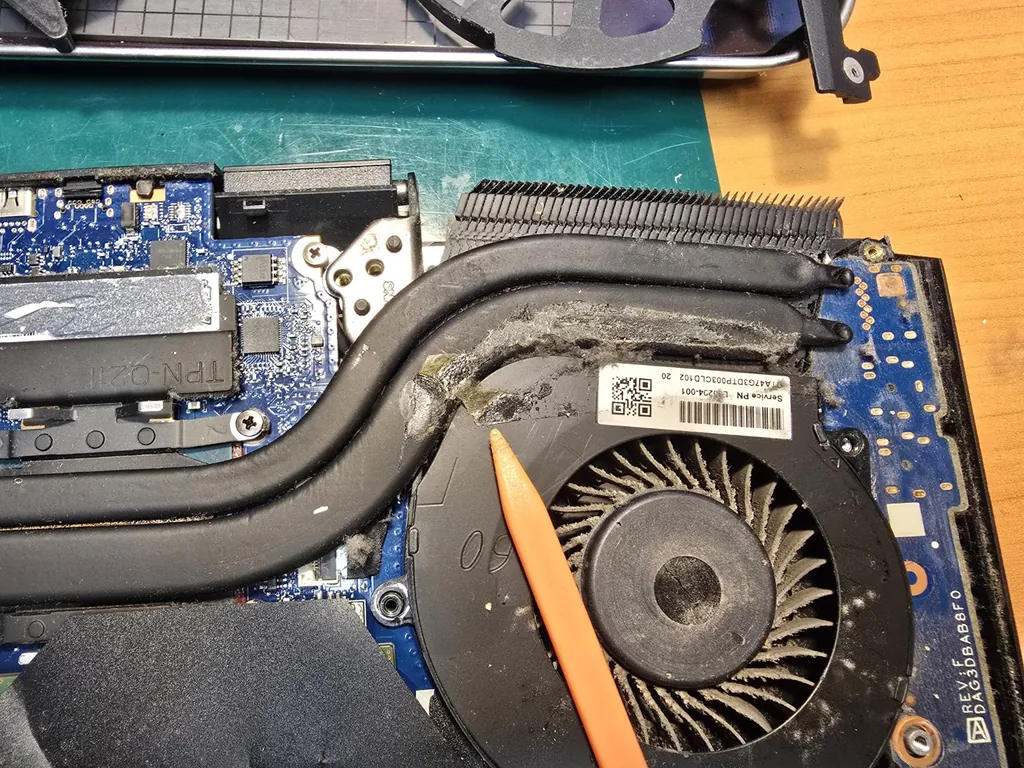 Zbliżenie na lewy wentylator i radiator w HP Omen 15-dc1xx z resztkami kleju przed czyszczeniem